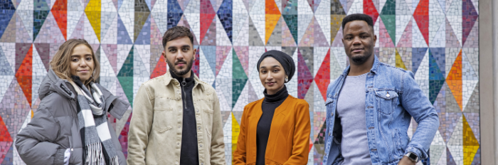 four Queen Mary students standing in front of a wall with a mosaic pattern