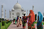 Women in traditional Indian dress walking in front of the Taj Mahal