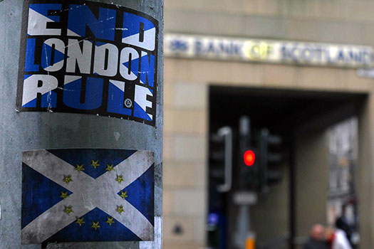 A lamp post with a sticker stating 'End London Rule' written against the Scottish flag, and another sticker below of the Scottish flag with the EU stars overlayed