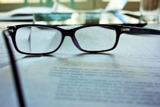 Pair of glasses on some academic papers
