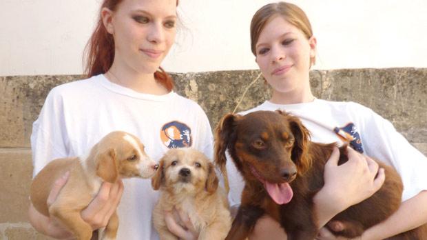 Two female volunteers holding dogs