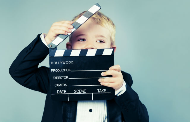 Photograph of a child with clapperboard
