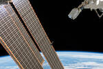 A CubeSat goes past the International Space Station's solar arrays 150px