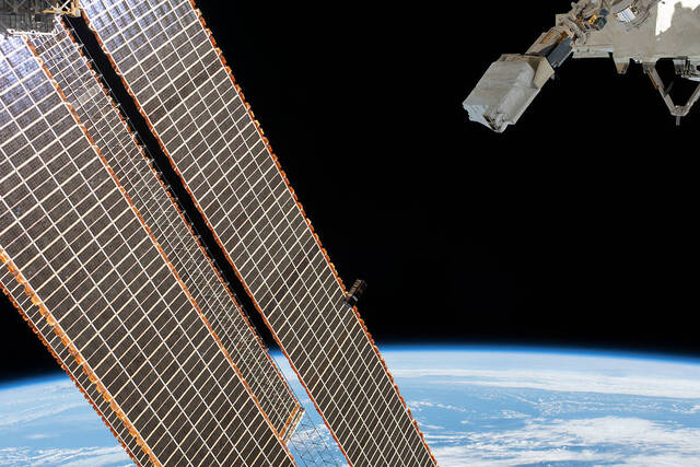 A CubeSat goes past the International Space Station's solar arrays - Credit:NASA