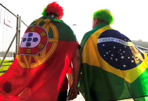 Two sports fans wrapped in a Portuguese and a Brazilian flag