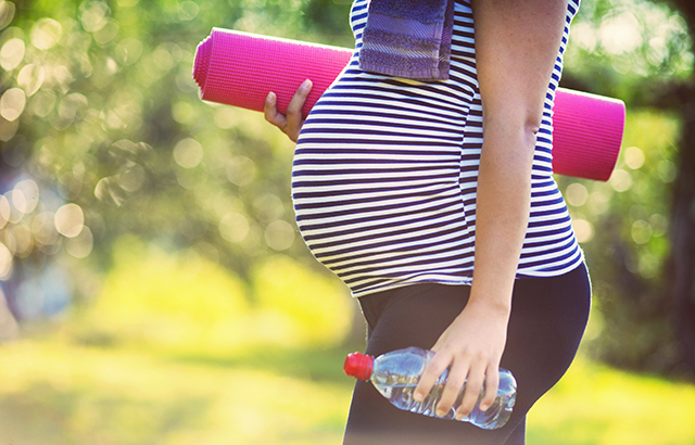 Pregnant woman holding exercise equipment