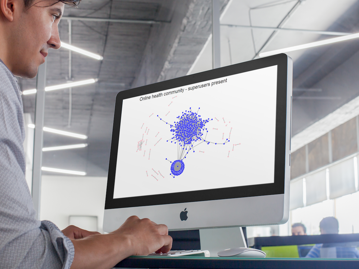 Man looking at online health community interactions displayed graphically on a computer