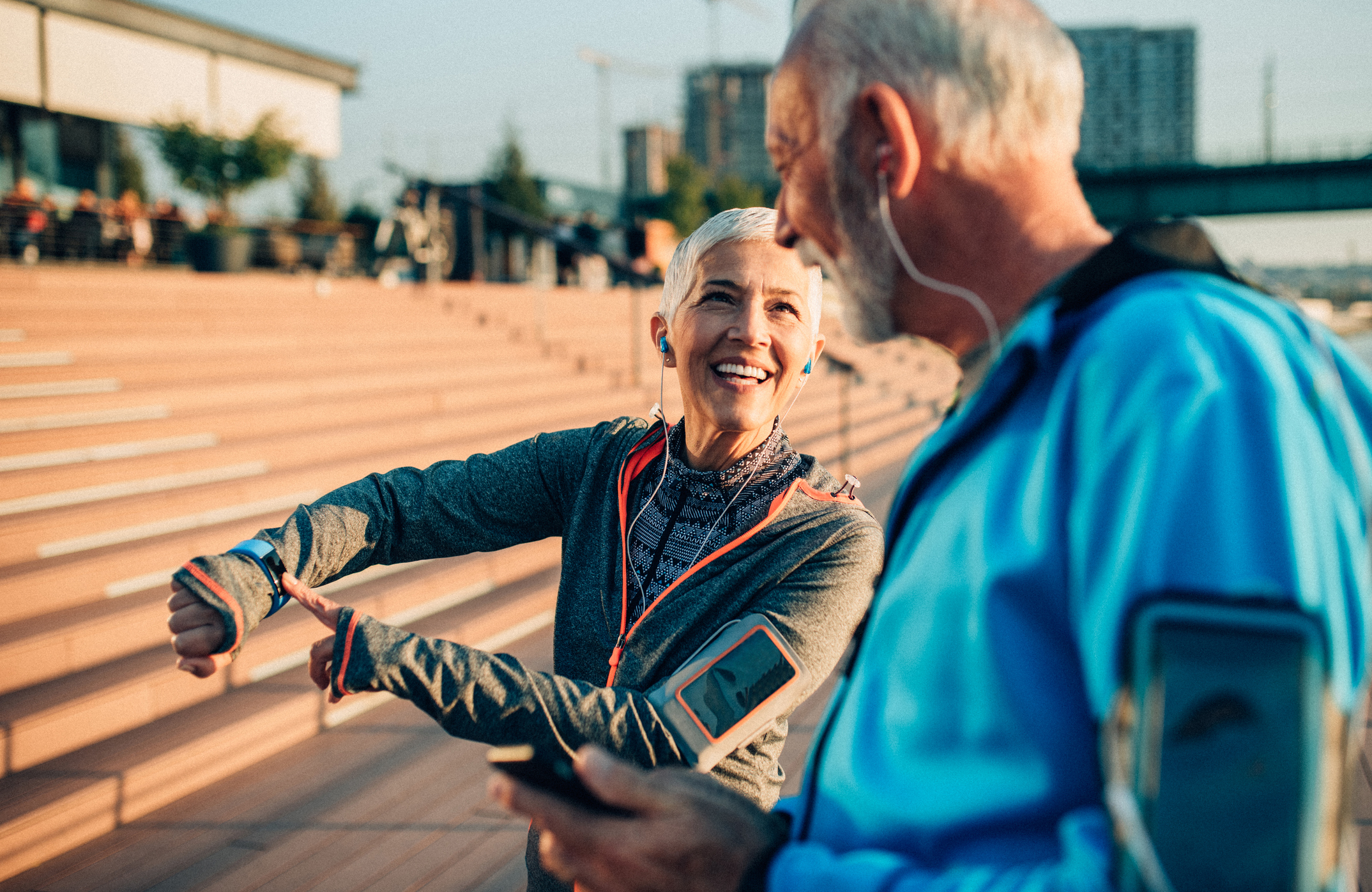 A woman talking to a man and pointing to her pedometer on her wrist