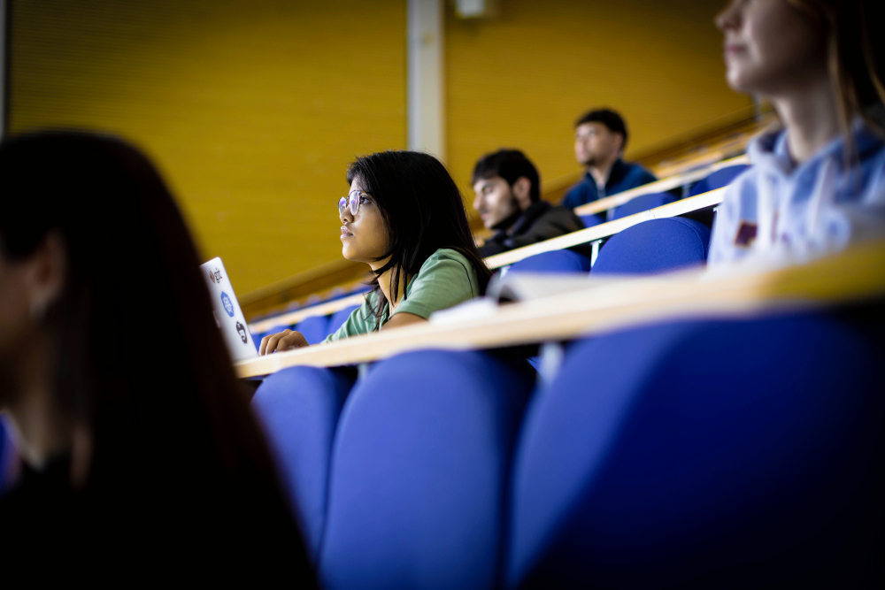 A girl with glasses sitting in a lecture