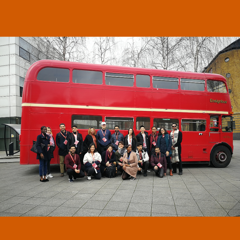 group of student in front of Red London double decker bus