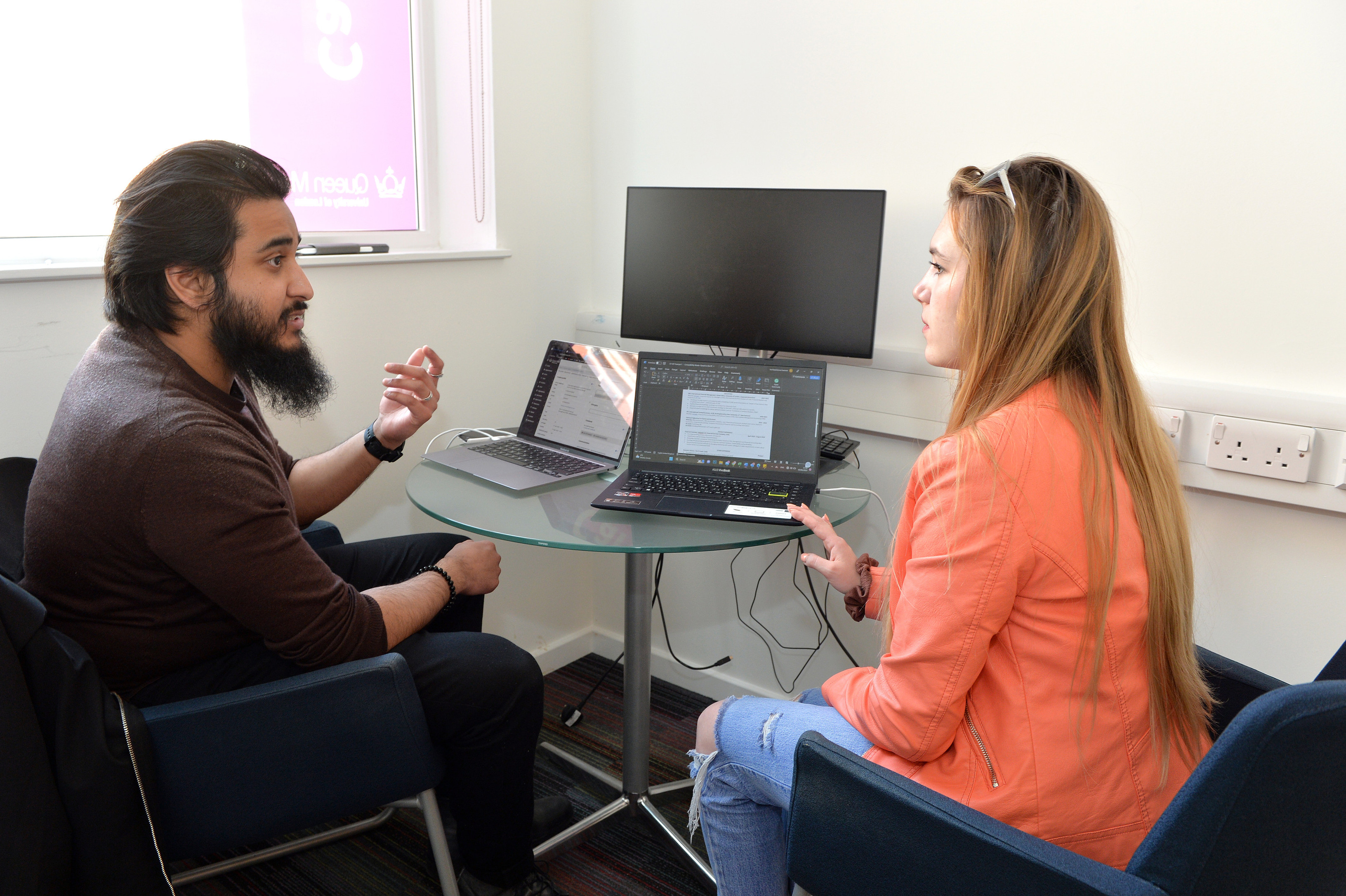 A picture of a careers advisor talking to a student inside an office