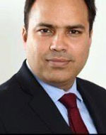 Ajit Mishra wearing a suit and red tie