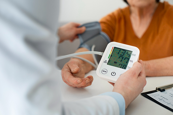 Photo of a health professional checking a patient's blood pressure