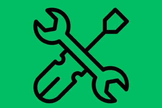 outline drawing of a spanner and screwdriver on a green backdrop