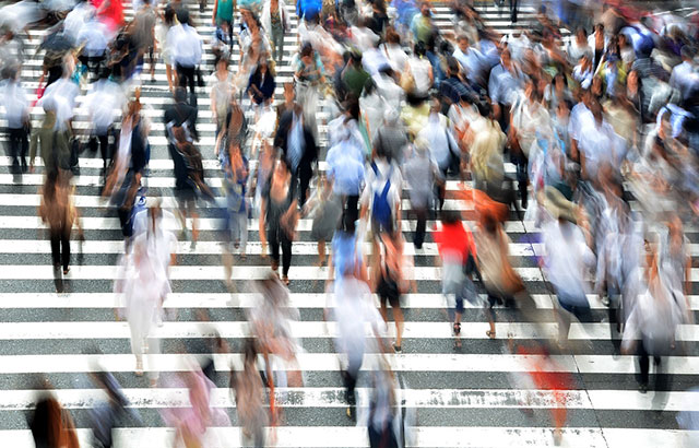 A motion blur images of pedestrians walking across a crossing in Osaka, Japan.
