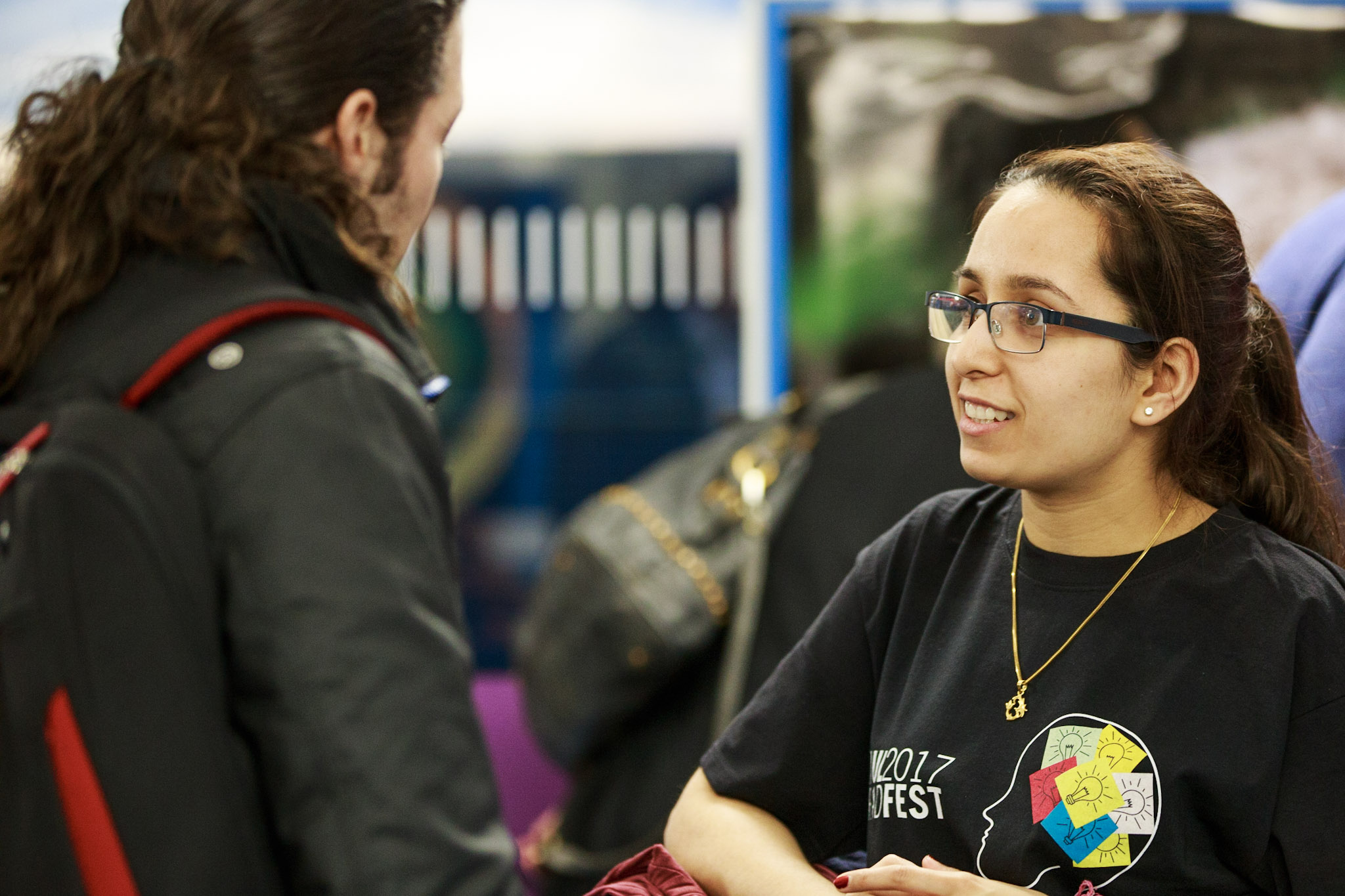 PhD student discussing their photo exhibited at Research Through a Lens event during 2017 Graduate Festival with attendees
