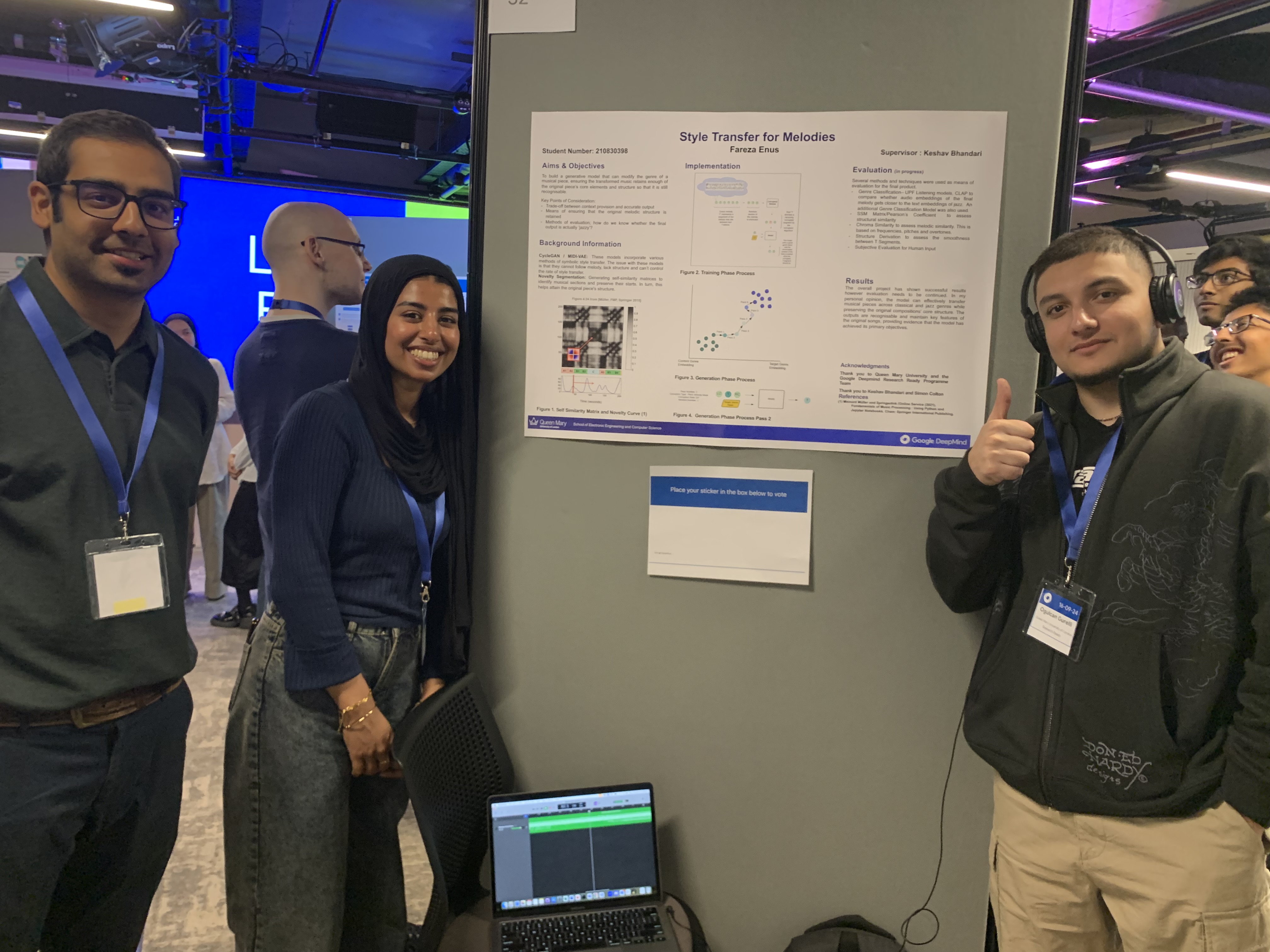 Three students around a poster board facing the camera