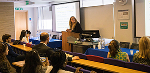 A person presenting research at an event to an audience at CCLS