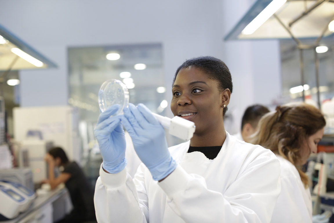 student holding a petri dish in a lab