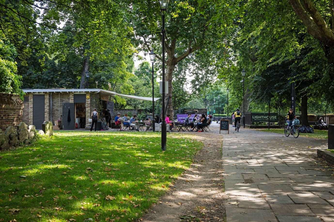 Green space with trees, path and a small house