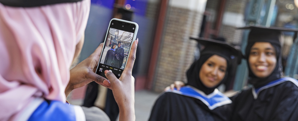 Two students being photographed at their graduaiton