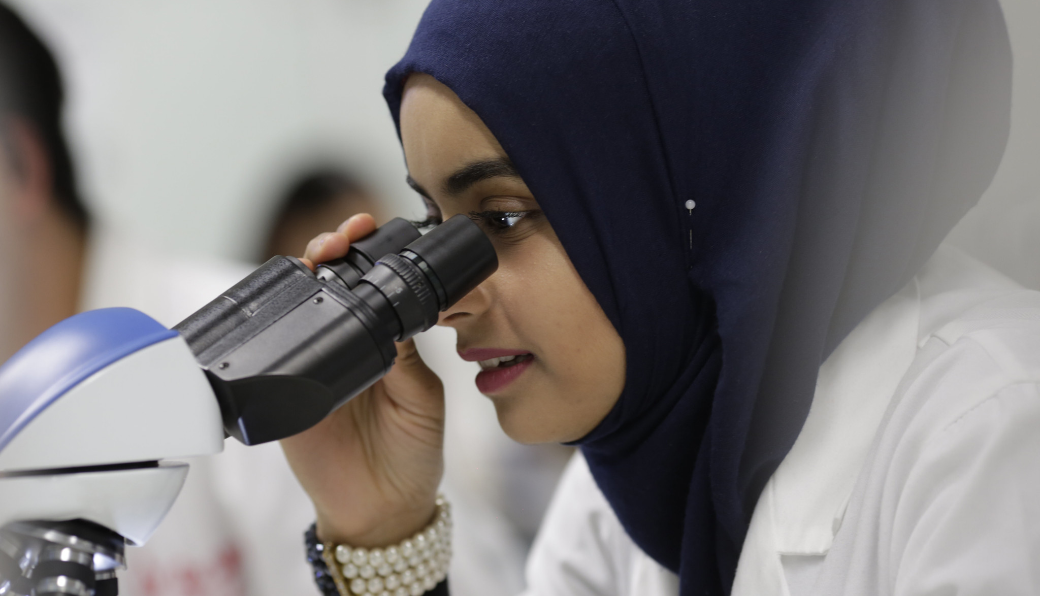 Image of a woman scientist looking through a microscope