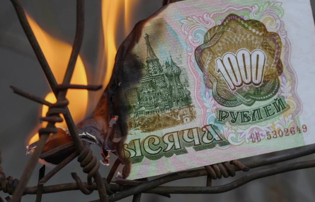 A burning Russian bank note on a piece of barbed wire
