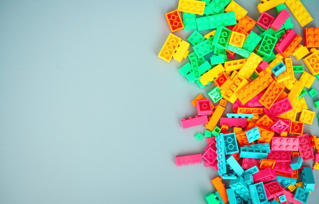 A selection of multicoloured plastic building bricks in a pile representing a lack of coordination