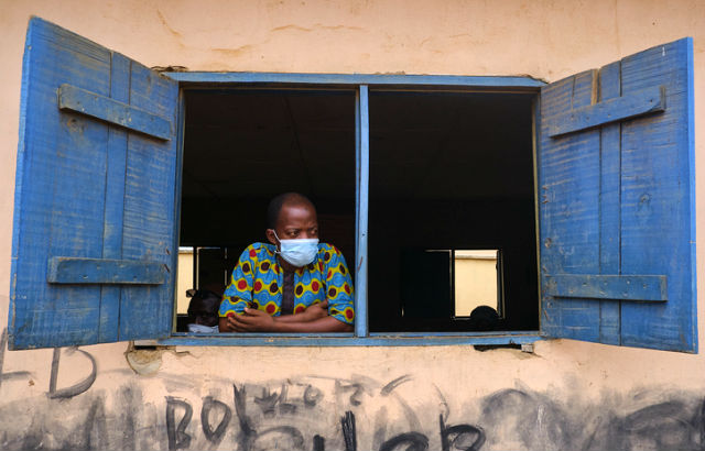 A man looks out the window at a venue for the Lagos State Environmental Protection Agency (LASEPA) and the Lagos State Safety Commission Social Distancing Advocacy program at Ikorodu, Lagos.