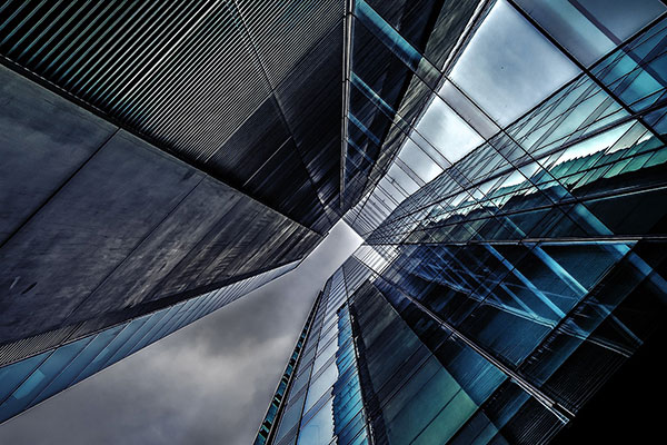 Glass fronted office buildings against a cloudy sky
