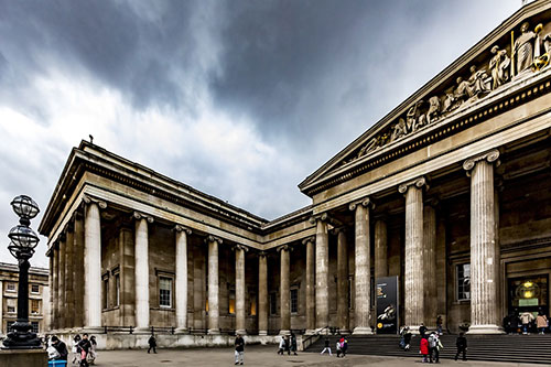 The front of the British Museum against a cloudy sky