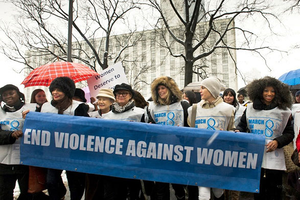 ‘UN Women For Peace’ March Marking International Women’s Day, with a group of women holding a banner stating 'End violence against women'