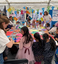 Children making art work at the LAC's I Am You stand at Queen Mary Festival of Communities