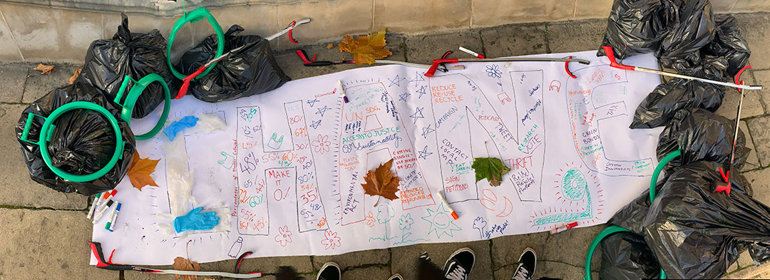 The student group's banner spelling out ‘CHANGE’ with collected rubbish and other tools