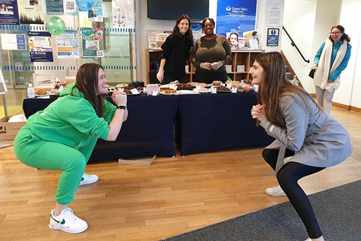 Queen Mary Legal Advice Centre Team members having a squatting competition at the Legal Bake 2022