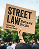 Street Law: Theory and Practice book cover. A person holding a placard at a protest with the title of the book written on it.