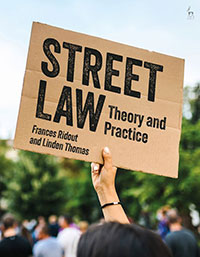 Street Law: Theory and Practice book cover. A person holding a placard at a protest with the title of the book written on it.