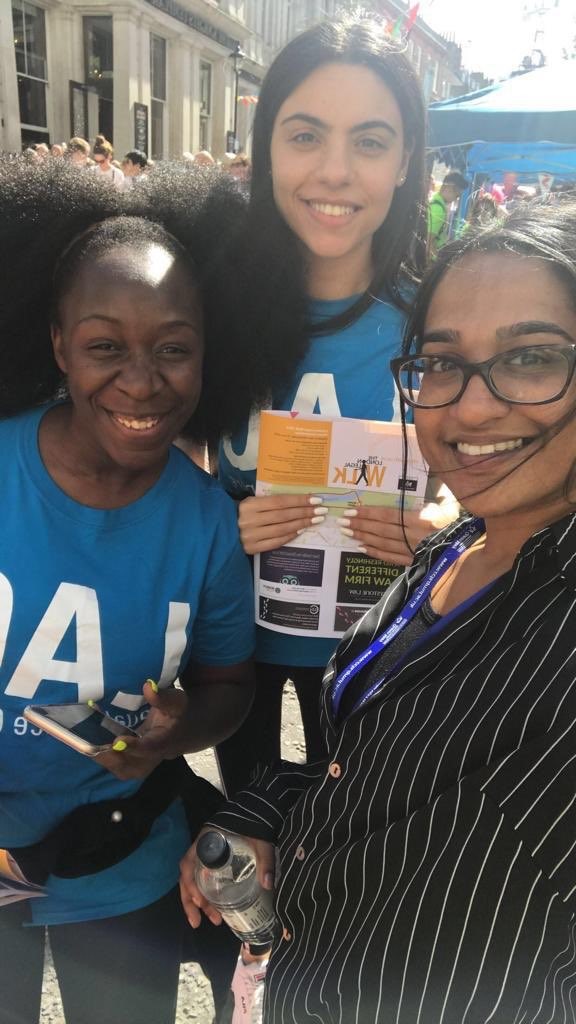 Three women stand close together smiling for the camera. Two of the women are wearing are wearing blue LAC t-shirts.