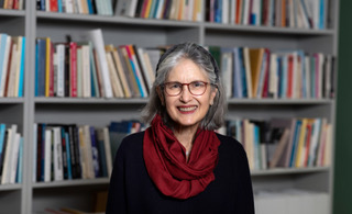 Professor Lorraine Daston sat in front of a book shelf