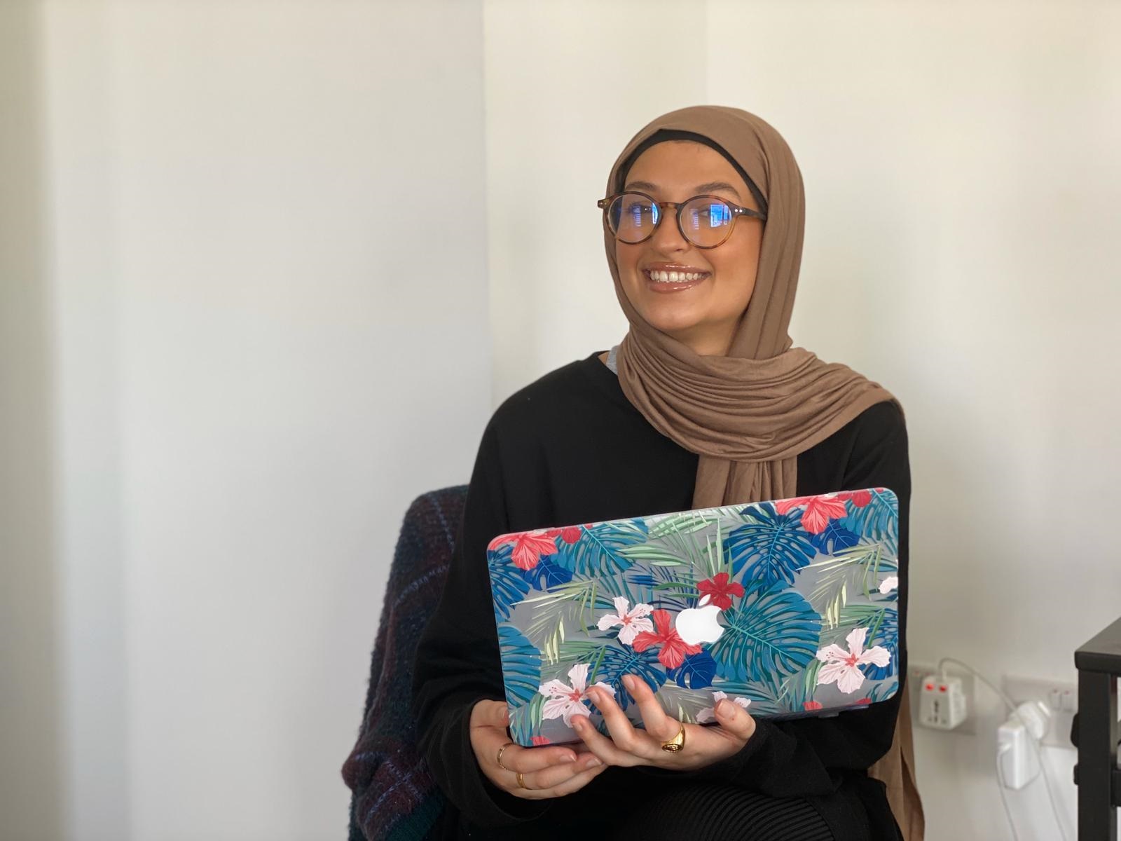 Assia Al Jerrari holding a laptop