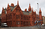 Victoria Law Courts in Birmingham. It is a red brick terracotta court building with spires and turrets, and reliefs carved on the walls.