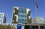 The exterior of the International Criminal Court. It's glass fronted with a living wall on either side of the building,
