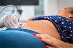 A pregnant person having an ultra sound taken