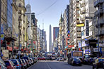 Buenos Aires street lined with cars and obelisk in the background