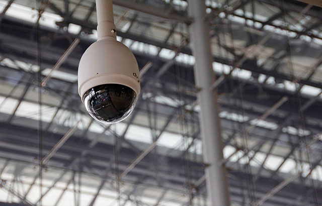 A security camera hanging from a ceiling