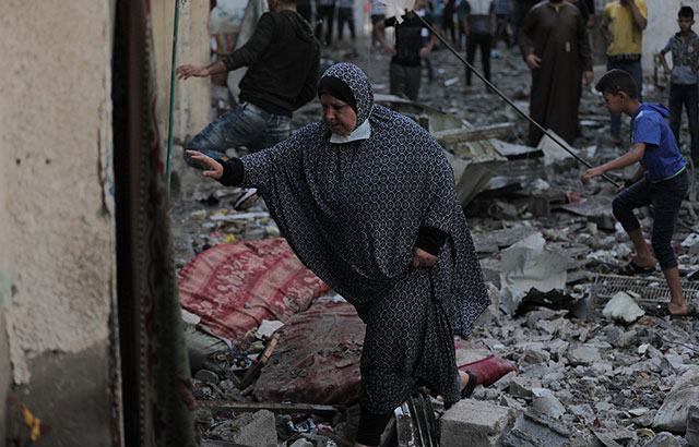 A woman walking among rubble in Gaza