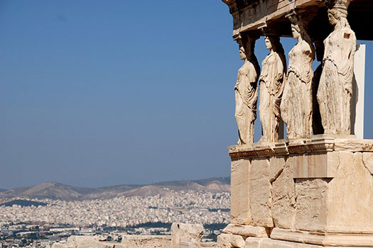 Statues at the Parthenon in Athens set against a view of the city