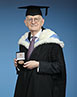 Ian Yeats in academic robes and holding his Queen Mary Medal