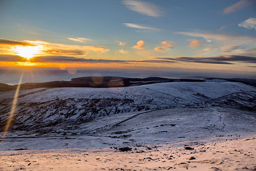 A sunrise over a snowy landscape on the Isle of Man