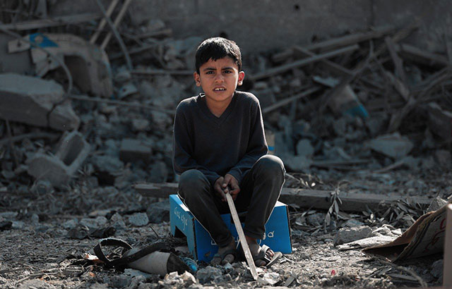 A child sat amongst rubble in Gaza